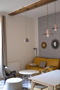 a living room with tables and a yellow couch at Cosy apartment ideally located in the Old Town in Lyon