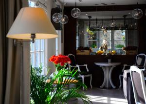 a lamp in a room with a table and chairs at Hôtel Eze Hermitage entre Nice et Monaco in Éze