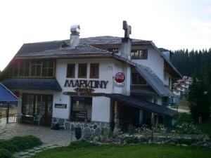 a large white building with a sign on it at Family Hotel Markony in Pamporovo