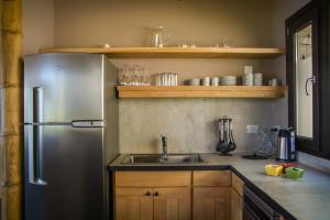a kitchen with a stainless steel refrigerator and a sink at Correntoso TownHouses in Villa La Angostura