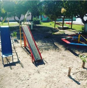 un parque infantil con un tobogán en la arena en Guarajuba sitiofelizcidade en Guarajuba