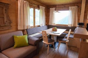 a dining room with a table and a couch at Ferienhütte Premstlahof in Martello