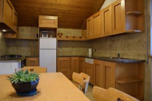 a kitchen with a table and a white refrigerator at La Casa Duron in Campitello di Fassa