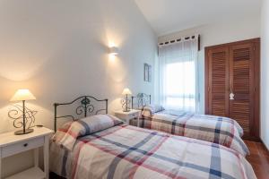 una camera da letto con due letti e una finestra di Moradia T3 Soltroia Mar a Tróia Altre 19 foto
