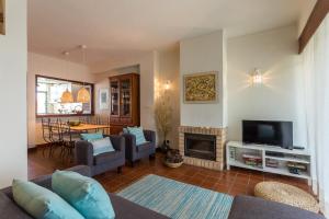 uma sala de estar com um sofá e uma televisão em Moradia T3 Soltroia Mar em Tróia