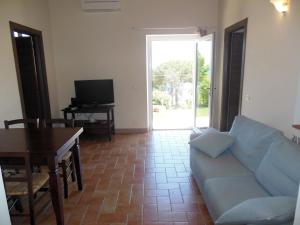 a living room with a couch and a table and a television at La Casa Di Ninetta in Rio Marina