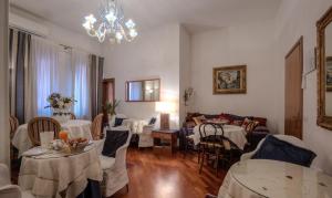 a living room with tables and chairs and a chandelier at Ca' della Corte in Venice
