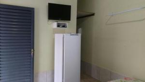 a white refrigerator in a room with a tv on the wall at Pousada Agua Quente in Rio Quente +18 photos