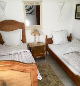 two beds in a room with a mirror and a table at Ellekær-Gård in Dronninglund