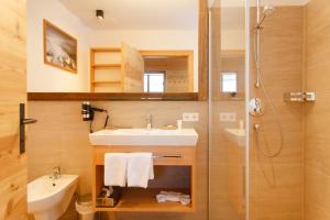 a bathroom with a sink and a shower at Trattlers Hof-Chalets in Bad Kleinkirchheim +58 photos