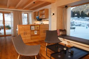 a living room with a couch and chairs and a table at Trattlers Hof-Chalets in Bad Kleinkirchheim
