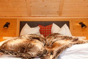 a large blanket laying on top of a bed at Trattlers Hof-Chalets in Bad Kleinkirchheim