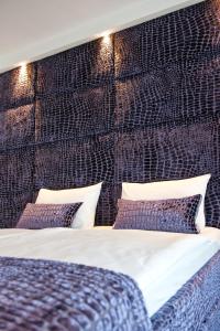 a bedroom with a bed with a padded wall at G Design Hotel in Ljubljana