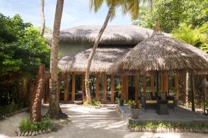 cabane tropicale avec chaises et toit de chaume dans l'établissement Taj Coral Reef Resort & Spa,Maldives - Premium All Inclusive with Free Transfers, à Atoll Malé Nord