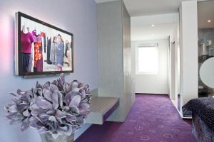a living room with a tv and a plant at G Design Hotel in Ljubljana