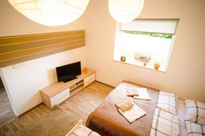 Kleines Zimmer mit einem Bett und einem Flachbild-TV. in der Unterkunft Green Garden in Šip