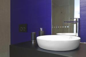 a bathroom with a white sink and a purple wall at G Design Hotel in Ljubljana