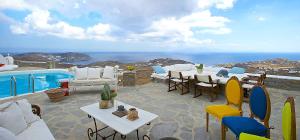 アノ・メラにあるVilla Aether Mykonosの海の景色を望むパティオ(テーブル、椅子付)