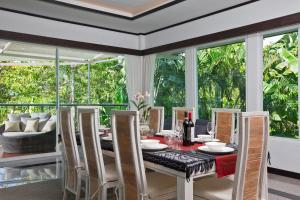 una sala da pranzo con tavolo e sedie di Villa Sirion a Kamala Beach