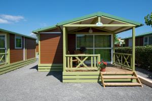 a green and orange tiny house with a porch at Camping Villasol in Benidorm
