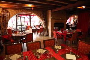 un restaurant avec tables et chaises et nappes rouges dans l'établissement La Table Des Bons Peres, à Bislée