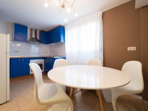 een keuken met een witte tafel en witte stoelen bij El Despertar in Boltaña +5 foto's