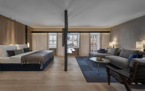a bedroom with a bed and a living room with a couch at Hotel Weisses Roessl in Kitzbühel