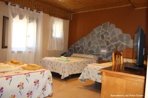 a room with two beds and a rock wall at Hotel Spa Venta Ticiano in Yeste