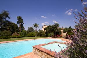 a swimming pool in a yard with a house at Villa Il Trebbio in Cortona