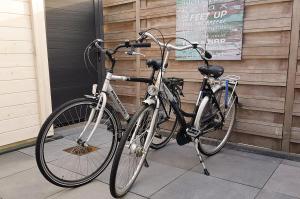 two bikes parked next to each other on a sidewalk at INTIKA Beach House in Zandvoort