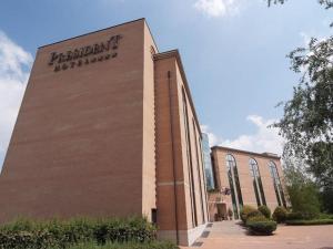 un edificio de ladrillo con un cartel en el costado en Hotel President, en Correggio