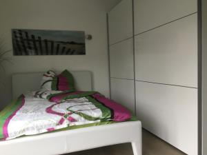 a bedroom with a bed and a white cabinet at Stadtvilla Intzeplatz - Apartment Juist in Remscheid