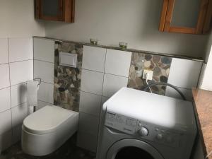 ein Badezimmer mit einer Waschmaschine und einem WC in der Unterkunft Stadtvilla Intzeplatz - Apartment Juist in Remscheid