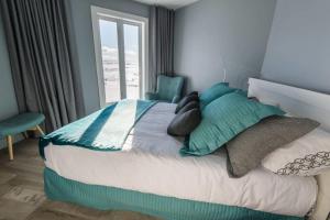 a bedroom with a large bed with pillows and a window at 227 - En bordure de la rivière du Gouffre - Les Immeubles Charlevoix in Baie-Saint-Paul