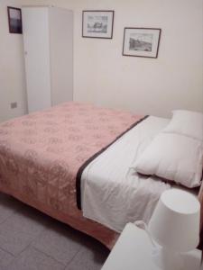 een slaapkamer met een groot bed met witte lakens bij Su Matutzu in San Giovanni Suèrgiu