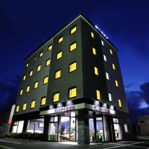 a tall black building with yellow lights on it at Sunstay Kaseda in Kaseda