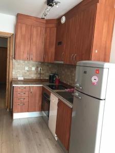 a kitchen with wooden cabinets and a refrigerator at Font Romeu Via (Maison du Soleil) in Font-Romeu-Odeillo-Via