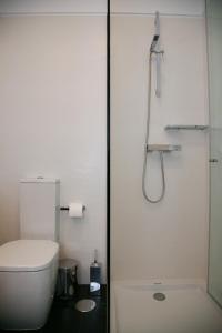 y baño blanco con aseo y ducha. en Casa D' Joao Enes - Afife Residence, en Afife