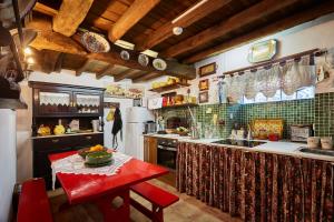 uma grande cozinha com uma mesa vermelha em Sotam Country House em Góis