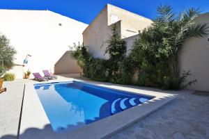 a swimming pool in front of a house at Flowers House in Maria de la Salut