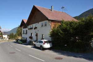 une voiture blanche garée devant une maison dans l'établissement Ferienhaus Heidi, à Piller