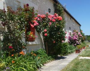een gebouw met bloemen aan de zijkant bij La maison des fleurs in Saint-Senoch