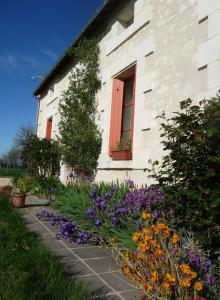 een huis met een bloementuin ervoor bij La maison des fleurs in Saint-Senoch