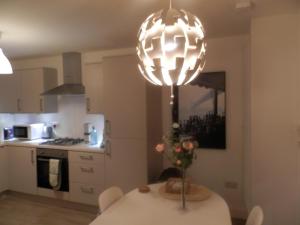 a kitchen with a table and a large light fixture at The Archers in Perth