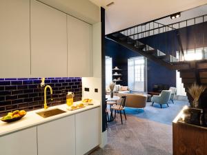 a kitchen with a sink and a living room at Apartamentos The Arc Carrís in Porto