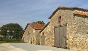 an old stone building with a wooden door at Gites de la noue in Vendrennes