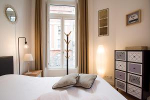 een slaapkamer met een wit bed en een raam bij Le Saint-Aubin by Cocoonr in Toulouse