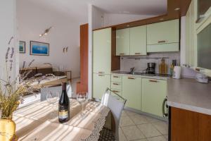 une cuisine avec une table avec une bouteille de vin dans l'établissement Apartman Zrinko, à Dramalj