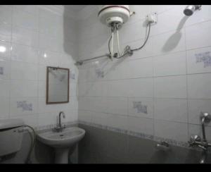 a bathroom with a sink and a toilet and a mirror at Hotel Rajpal Guest House in Dehradun