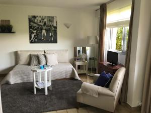 サントロペにあるSaint-Tropez - Studio 40 m2のリビングルーム(ベッド1台、ソファ、椅子付)